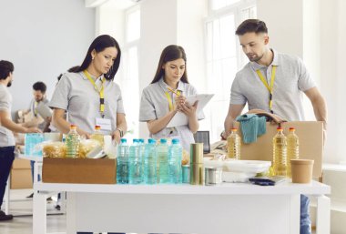 Bir grup genç gönüllü yiyecekleri kutulara koyuyor, yakın plan. Hayır işçileri bir depoda yiyecek dağıtıyorlar. Kavramsal insani yardım, hayır kurumu, gıda bankası, organizasyon