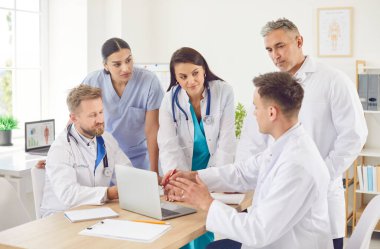 Bir grup doktor ve hemşire hastanede bir toplantı veya konferans düzenleyerek sağlık hizmetleri tartışmaları ve tıbbi planlama için dizüstü bilgisayar kullandılar. Takım çalışması ve sağlık hizmetlerine bağlılık.