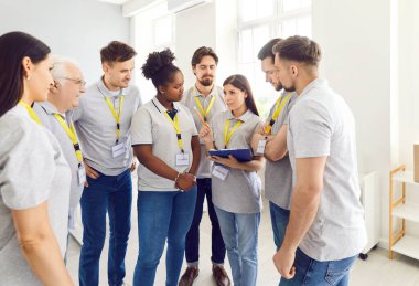 Gönüllülerden oluşan bir ekip, bir insani yardım merkezindeki toplantı sırasında iletişim kuruyor. Sosyal yardım ve takım çalışmasına olan bağlılıklarını vurgulayarak hayır, bağış ve toplumsal çalışma konularını tartışıyorlar..