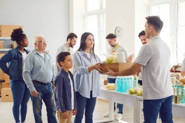 Kâr amacı gütmeyen bir organizasyon merkezinde yiyecek yardımı alan bir grup insan. Gönüllülerden oluşan bir ekip, etnik çeşitliliğe ihtiyaç duyan vatandaşlara yiyecek ve hijyen malzemeleri veriyor. Yardım, yardım ve bağış konsepti