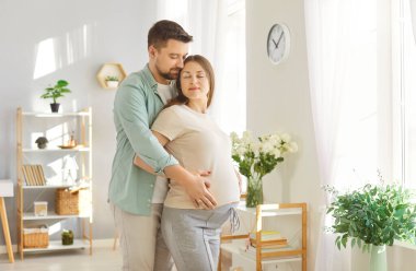Sevgi dolu bir bakım, aile çiftleri, genç müstakbel ebeveynler, ilk bebeği evde bekleyen, şefkatli koca ve hamile eş, sevgiyi ifade eden, okşayan, ebeveynlik, yeni hayat, planlama, hayal kurma