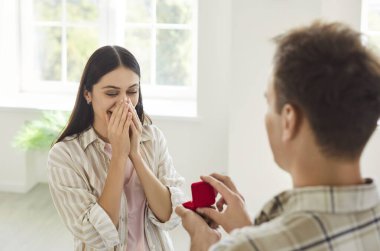 Evlenme teklif et, kırmızı kutulu adam nişan yüzüğü, hazırlık, aşk dolu bir kadına evlenme teklif et, kız arkadaşın ellerinde yüzünü kapatsın, romantik sevgililer günü hediyesi sunsun.