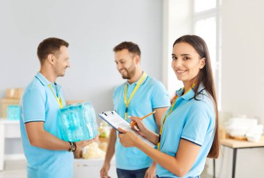 İnsani yardım merkezinde birlikte çalışan bir grup neşeli genç gönüllü. Dost canlısı ekip yardım ve sosyal destek sağlama, bağışları paketleme ve toplum üzerinde olumlu etki yaratma üzerinde odaklandı.