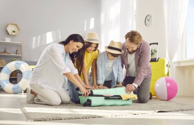 Aile tatili mutlu bir şekilde bavul hazırlamak, planlamak, seyahat ve eğlence için hazırlanmak. Aileler ve çocuklar keyif almanın ya da deniz rahatlamasının hayalini kuruyor, tatil gezisine, yaz yolculuğuna çıkıyorlar.