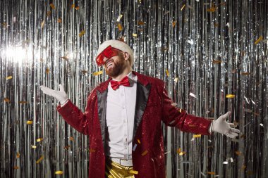 Noel Baba şapkası takan mutlu yeni yıl adamı, gece kulübü eğlencesi içinde kırmızı ceket giyen, Noel tatilcisi dans eden adam parti gecesi için komik bir kostüm giyen, geleneksel kulüp toplama festivali