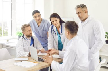 Meslektaşlarının ofisindeki bir grup doktor çalışma sürecini yakın plan olarak tartışıyor. Doktorların müşterek tartışması. Tedavi yöntemi ve danışma konusunda bir karar vermek. Hastane ekip çalışması