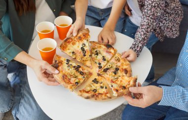 İnsanlar pizza yiyor, arkadaşlar pizzacıda bir araya geliyor. Lezzetli fast food 'ları paylaşıyorlar. Çeşitli meslekdaşlar barda yemek yemek yemek için dilimler yiyorlar. 