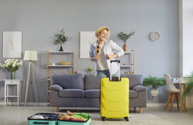 Neşeli kadın gezgin sonunda yaz tatili başladığında neşeli bir ruh hali içindeydi. Tatilini planlıyordu. Oturma odasında bavulunun yanında tasasız bir şekilde dans ediyordu. Turizm ve seyahat kavramı