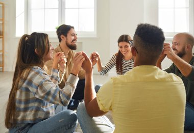 Bir grup mutlu genç birlikte eğleniyor. Neşeli melez ırk arkadaşları evde daireler çizip el ele tutuşup komik şakalara gülüyorlar. Topluluk ve arkadaşlık kavramı