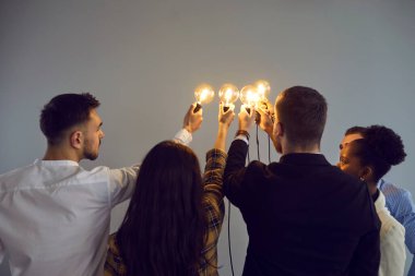 Çeşitli iş adamları Edison 'un ampullerini tutuyor. Bir grup genç, takım arkadaşı, şirket çalışanı ve ofis çalışanı, yaratıcı topluluktaki fikirleri paylaşma sembolü olarak elektrik ampullerine katılıyor.