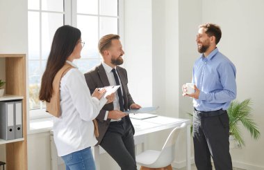 İş arkadaşları ofiste fikirleri tartışıyor ve beyin fırtınası yapıyorlar. Çalışma sürecinden bahseden mutlu iş adamları proje sonuçlarını tartışıyor, gülümsüyor ve birbirleriyle iletişim kuruyorlar.