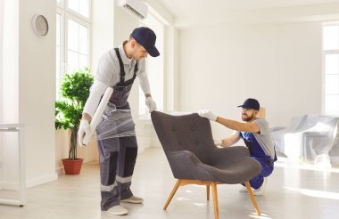 Taşınmak için plastik mobilya kılıfları, teslimat servisi, erkek nakliyeciler ev eşyalarının yüklenmesi ve yerleştirilmesi, yeni ev eşyaları, ofis odasındaki karton taşınma kutularının taşınması