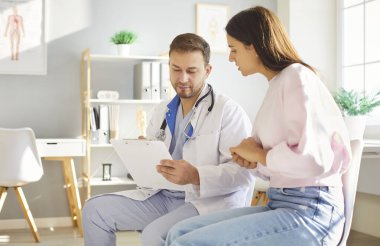 Yoğunlaşmış erkek doktor ya da hemşire hastanede tıbbi bir konsültasyon sırasında bir hastayla iletişim kuruyor ve onunla konuşuyor. Profesyonel destek, sağlık hizmetleri iletişimi ve şefkatli bakım..