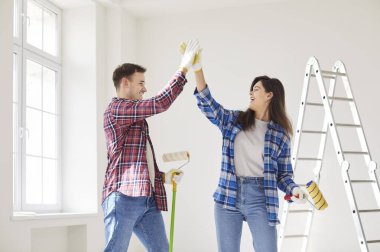 Gülümseyen mutlu çift yeni dairelerinin duvarını boyarken bir beşlik çakıyor. Evli bir adam ve kadın tadilat yapıyor. Yeni bir daireye taşınmaya hazırlanıyorlar..