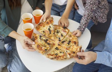 İnsanlar pizza yiyor, arkadaşlar pizzacıda bir araya geliyor. Lezzetli fast food 'ları paylaşıyorlar. Çeşitli meslekdaşlar barda yemek yemek yemek için dilimler yiyorlar. 