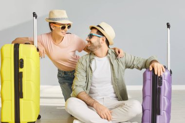 Erkek arkadaşlarıyla balayını deniz kenarında geçirip yaz turuna hazırlanırken, şapka ve güneş gözlüğü takıp bavullarla poz verirken çekilen kapalı çekimler. Kadın ve erkek tatil planlıyor