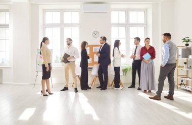 Bir toplantı ya da konferanstan sonra konuşan kendinden emin genç iş adamları. Şirket çalışanları ofiste çalışıyor, iş ve iş projelerini tartışıyor. Takım çalışması konsepti.