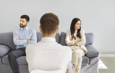 Terapist ofisindeki kanepede oturan ve birbirlerini görmezden gelen genç üzgün aile çifti. Psikoloğun, hayal kırıklığına uğramış kadın ve erkeğin sorunlarını çözmeye çalışmasının arka planı..