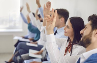 Modern bir ofiste iş toplantısı, sunum ya da etkinlik sırasında soru sormak için toplanan iş adamlarının el ele tutuşmalarına yakından bakın. Profesyonel grup tartışmaları ve sunumları.