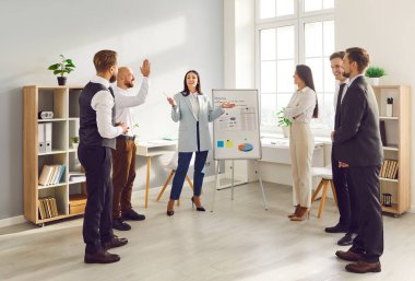 İş kadını ofis çalışanlarının sunumunu yönetiyor takım çalışmasının gücü ofis işinin öneminden geliyor. Ofis çalışmalarında stratejik planlama, ticari hedeflere ulaşmada işbirliğinin öneminin altını çizmektedir