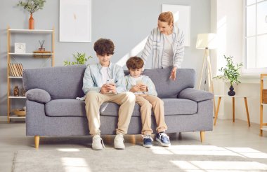 Anneler, internetteki oyunlara ve sosyal medyaya bağımlı çocukları azarlıyor. Çocukların internet kullanımını yönetmekle ilgili modern ebeveynlik sorunları.