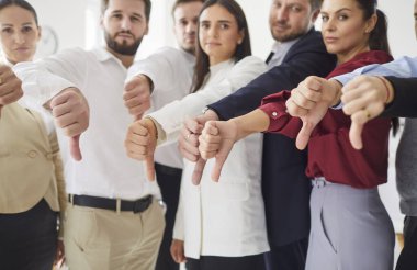 Ofiste bir araya gelmiş ciddi profesyonellerden oluşan bir grup, hepsi baş parmak işareti yapıyor. Genç iş adamlarından oluşan bir ekip memnuniyetsizlik ya da hoşnutsuzluğu ifade ediyor, hoşnutsuzluk ve reddetme gösteriyor..