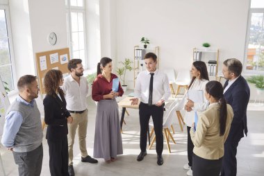 Bir grup kendine güvenen iş adamı iş projesini tartışırken ofiste daireler çiziyor. Şirket çalışanları, konferans odasında iş arkadaşlarını dinliyorlar..