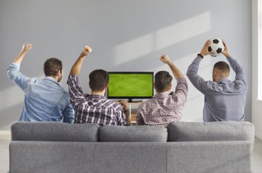Evdeki rahat kanepede oturan erkekler televizyonda canlı futbol maçı izliyorlar. 4 arkadaş kanepede oturup TV 'de ilginç futbol şampiyonası izliyorlar, tezahürat yapıyorlar, favori takımı destekliyorlar, dikiz aynasından izliyorlar.