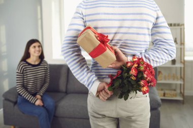 Sevgililer Günü. Çiçek tutan bir adamın arka görüntüsü ve bir kıza elinde bir hediye verir..