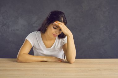 Mutsuz, genç, beyaz bir kadın masasında oturuyor ve kötü haberler yüzünden bunalımda. Yeni nesil Z kadınlarının ağlayışları ilişki sorunları yüzünden tedirgin. Depresyon, endişe konsepti.