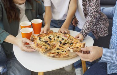 Ailede iki çocuklu bir ailenin, öğle yemeğinde fast food pizza yerken, keyifli ve bağlantılı sıcak bir ortamda eğlenirken yakın plan çekimleri..
