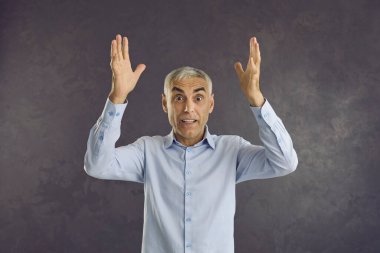 Stüdyonun arka planında sersemlemiş orta yaşlı bir adamın portresi iyi haberlerle şaşkına dönmüş durumda. Şaşırtıcı yetişkin beyaz erkek kamera zaferine bakar beklenmedik bir mesajla şaşırır..