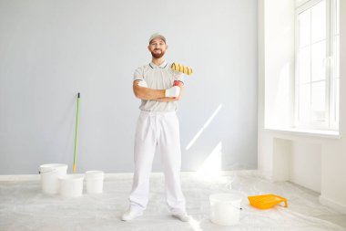 Ev yenileme çalışmaları sırasında gülümseyen bir ressam ya da tamirci portresi. Profesyonel uzmanlık ve neşeli tutum, inşaat ve onarım görevlerine dostça bir dokunuş ekliyor.