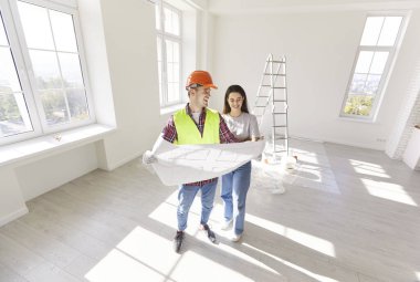 Erkek mimar ve kadın müvekkil yeni ev planlarını gözden geçiriyorlar. Tadilat ve inşaatı birlikte planlıyorlar. Olumlu tartışmalar işbirlikçi planlama ve proje geliştirmeye odaklanıyor.