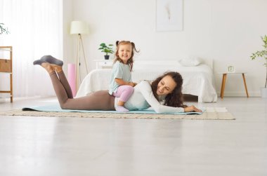 Mutlu aktif, eğlenceli aile oyunu, anne-baba, bebek bakıcısı, tatlı küçük kız birlikte oturma odasının içinde, kaygısız küçük çocuk arkada oturmuş eğleniyor, eğleniyor ve evde eğleniyor.