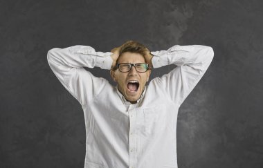 Siyah stüdyodaki öfkeli genç adam beklenmedik kötü haberlerle çığlık atıyor. Kızgın kızgın çılgın milenyum jenerasyonu erkek yüksek sesle umutsuzluk endişesi bağırıyor. Çaresiz hisseden adam panik yaratır..