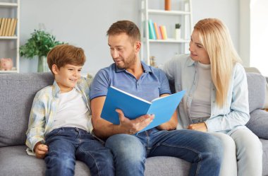 Gülümseyen ebeveynler kanepede oturmuş neşeli oğullarıyla konuşuyor, kitap okuyor, fotoğraf albümüne bakıyor ya da ev ödevlerine bakıyor. Anne ve baba evdeki kanepede bir şeyler söyleyen çocuğu dinliyorlar..