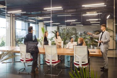 Çeşitli milenyum iş adamları brifingi, modern toplantı odasında konuşma, şeffaf cam duvar panoramik penceresinin arkasındaki proje üzerinde müzakere, açık alanda anlaşma, modern ofis içi