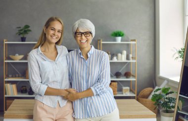 Gülümseyen Kafkasyalı olgun anne ve yetişkin kız kucaklaşmasının portresi ilişkilerde sevgi ve ilgi göstermektedir. Orta yaşlı mutlu bir anne ve yetişkin bir kızın aile fotoğrafı. Annelik kavramı.