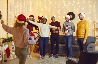 Noel Baba şapkalı bir grup çok ırklı genç arkadaş evdeki Noel partisinde bayan arkadaşlarına hoş geldin diyor. Kameraya arkası dönük bir kadın Noel hediyesini tutar ve kollarını açıp arkadaşlarına gider..