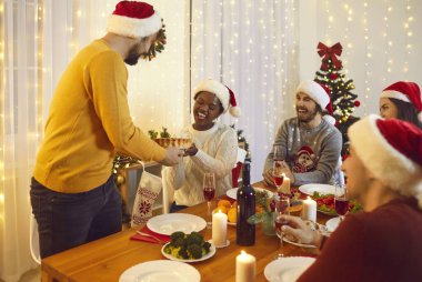 Neşeli adam evde arkadaşları ve ailesiyle birlikte Noel yemeği sırasında ev yapımı fırın servis eder. Noel arifesinde çok ırklı insanlar, dekoru olan bir odada şenlik masasında oturmuş eğleniyorlar..