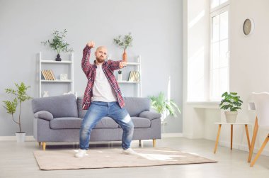 Evde tek başına dans eden pozitif bir adam, eğlenceli, aktif ve mutlu vakit geçiriyor. Müzik çalarken, kendi canlı parti atmosferini yaratıyor, dans ederek mutluluk ve neşeyi ifade ediyor..