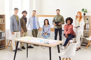 Mutlu genç meslektaşlar toplantı masasında beyin fırtınası yapmak, finansal planı, istatistikleri birlikte tartışmak, ofis toplantısında işbirliği yapan çok ırklı iş arkadaşları, takım çalışması... 