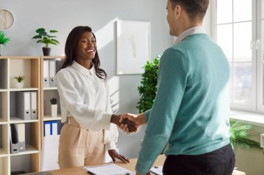 Mutlu Afro-Amerikan iş kadını, ofisteki müvekkil veya meslektaşlarına el sıkışma, anlaşma ve anlaşmayı onaylama, profesyonel bir ortamda ortaklık ve takım çalışmasını teşvik etme,.