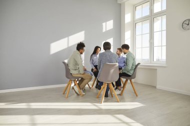 Modern bir ofiste konuşan bir grup insan. Şirket işletme ekibi bir iş toplantısı sırasında tartışıyor. Çeşitli erkek ve kadınlar grup terapisi sırasında iletişim kuruyor.