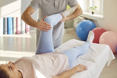 Rehabilitasyon diz, bacak masajı, düzeltici egzersiz ağrıyı azaltma, spor sakatlığı, eklem sağlığı, kas dengesizliğini düzeltme. Hemşire, manuel terapi doktoru hasta eğitimine yardım ediyor, iyi durumda.