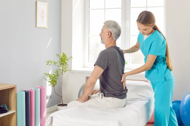 Yaşlılar için rehabilitasyon omurga egzersizi, yaşlı hasta, kadın fizyoterapist tarafından tıbbi klinikte tedavi, sırt kası eğitimi, vücut sağlığını iyileştirme.
