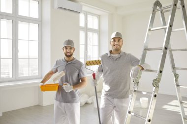 Mutlu profesyonel boya servisi, boyacı takımı, hazırlık yapan, bitirme işi yapan inşaat işçileri, oda rengi duvarlar, apartman dairesi yenileme, bakım ya da ofis onarımı 