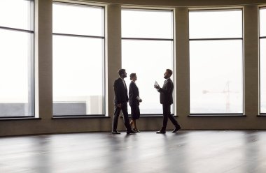 Emlakçı ya da komisyoncu, iş kadını, yeni boş bir ofis kiralamaktan mutlu, ev satın almaktan mutlu, emlakçı müşteriler ev kiralamaktan, yaratıcı modern uzay çalışmalarını keşfetmekten, büyük yaratıcılık alanlarını keşfetmekten mutlu.