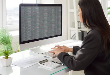 İş dünyasında çalışan iş kadını bilgisayarla muhasebe, denetim ve teftimde çalışıyor, hassas ve özenli bir ortamda profesyonel görevlere odaklanıyor..